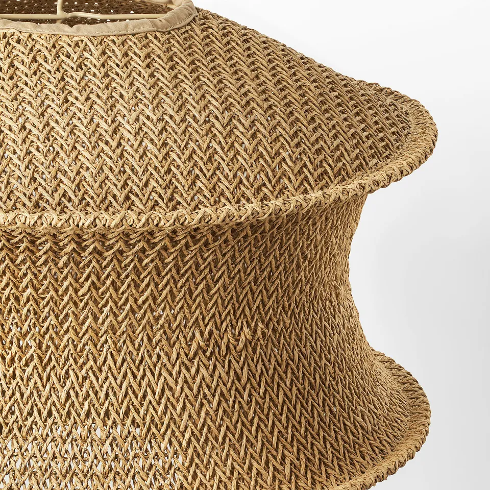 Close-up view of a woven pendant lamp shade. Intricate pattern with small holes for light diffusion. High-quality craftsmanship evident.