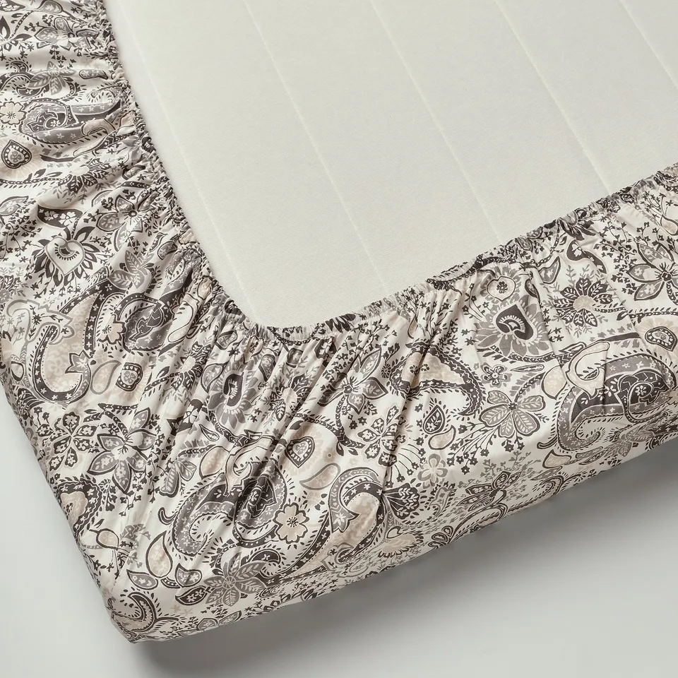A fitted sheet with paisley print, tailored for mattresses up to 26 cm thick, featuring soft cotton-viscose blend fabric.
