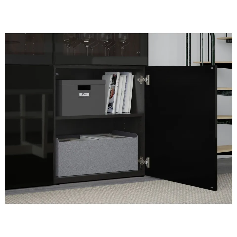 Open BESTÅ cabinet with grey organisers. Shows adjustable shelves and soft-closing doors, storing magazines and boxes.