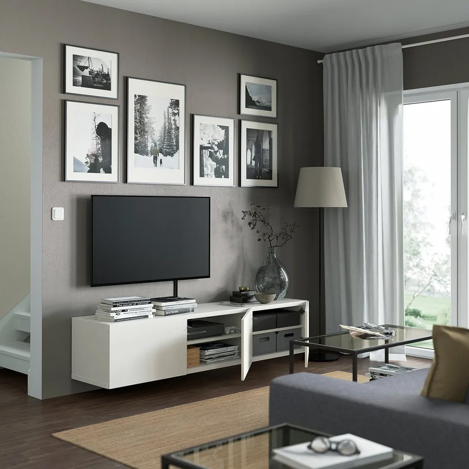 BESTÅ tv unit, flat screen on wall, black-and-white art, open storage, glass table, grey sofa, large window