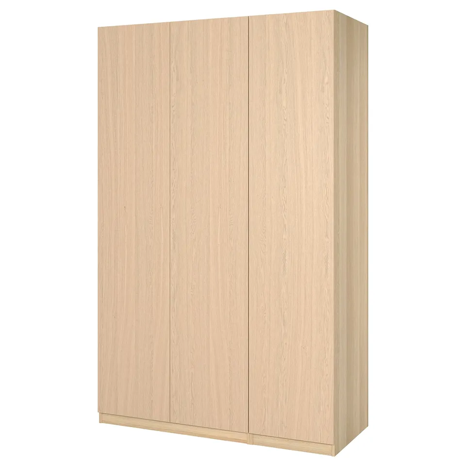 A light wood-colored ikea PAX wardrobe with three doors in a minimalist design.
