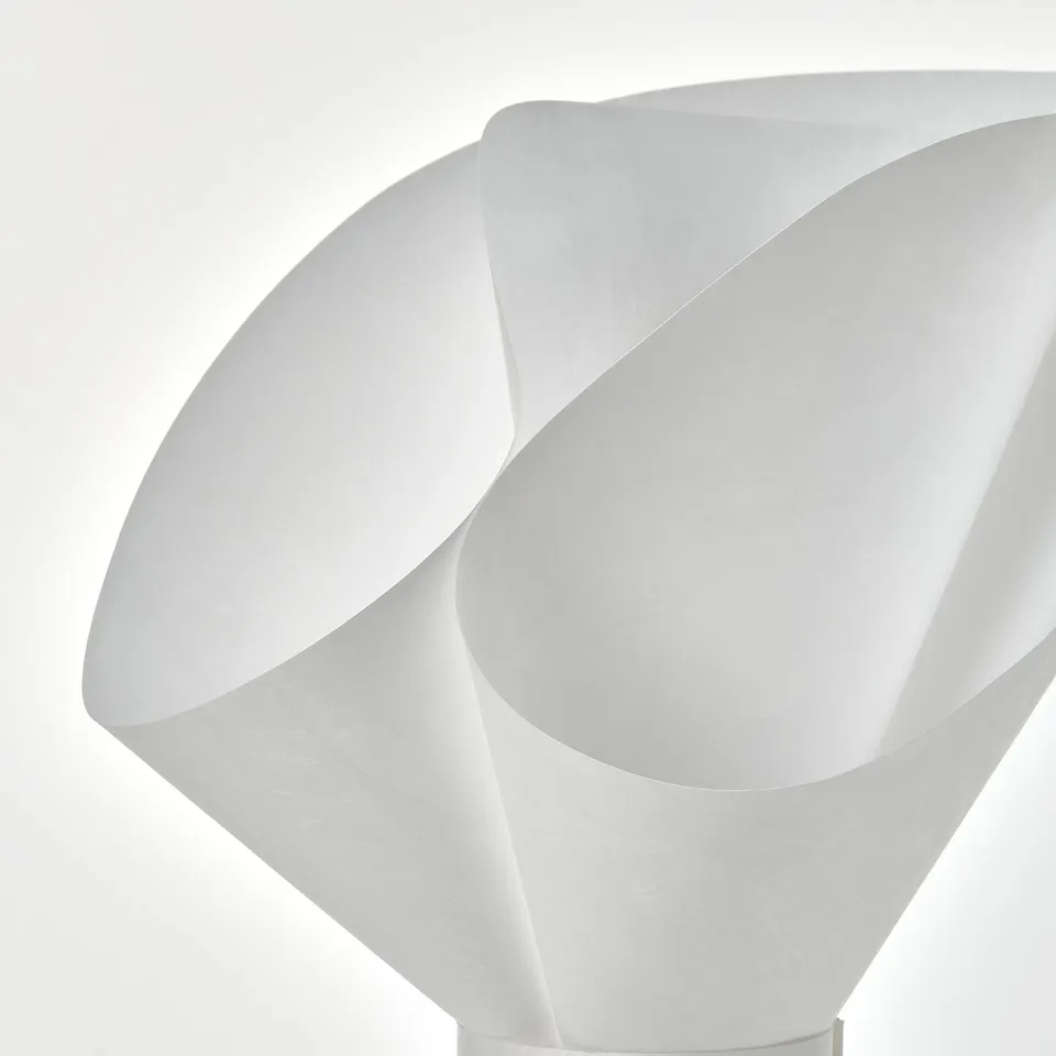 Modern table lamp with soft, flower-like design. Made from durable, recyclable synthetic material, emitting a warm, inviting light.