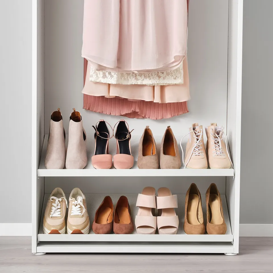 A shoe rack organises various footwear inside a closet, keeping them tidy and accessible.
