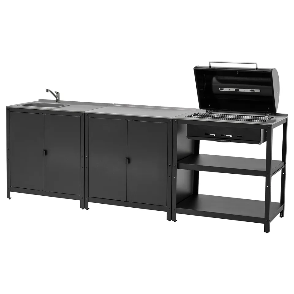 Black outdoor kitchen setup with sink and built-in charcoal grill. Multiple storage units and a countertop for food prep.