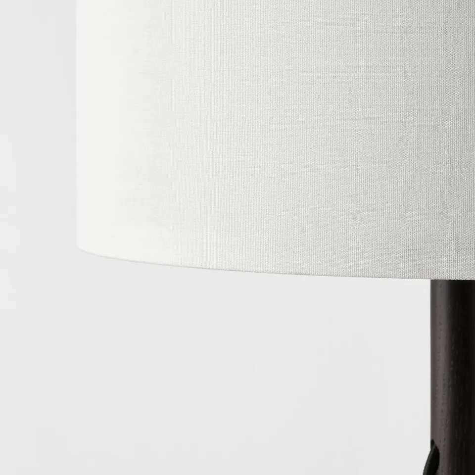 Elegant lamp with a white, textured shade and wooden base, displaying quality craftsmanship.