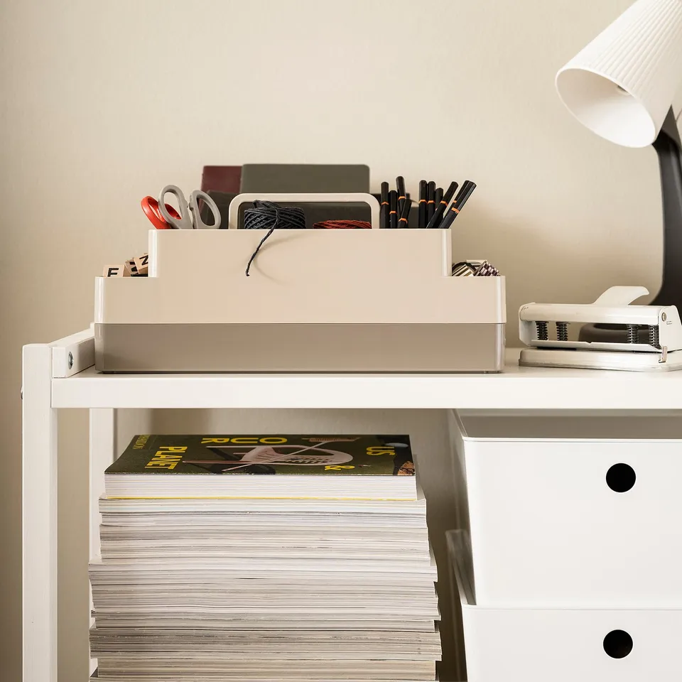 KUGGIS desk organiser, two-layered with top handle, stores small items and laptors. White, plastic. Fits well on surfaces beside a lamp and books.