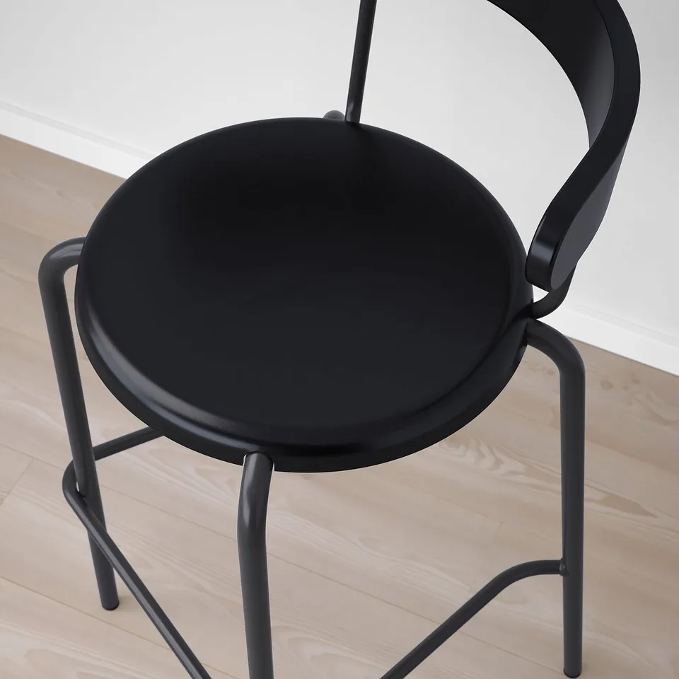 Modern black bar stool with sleek, curved design. A round seat and compact frame, ideal for small spaces.