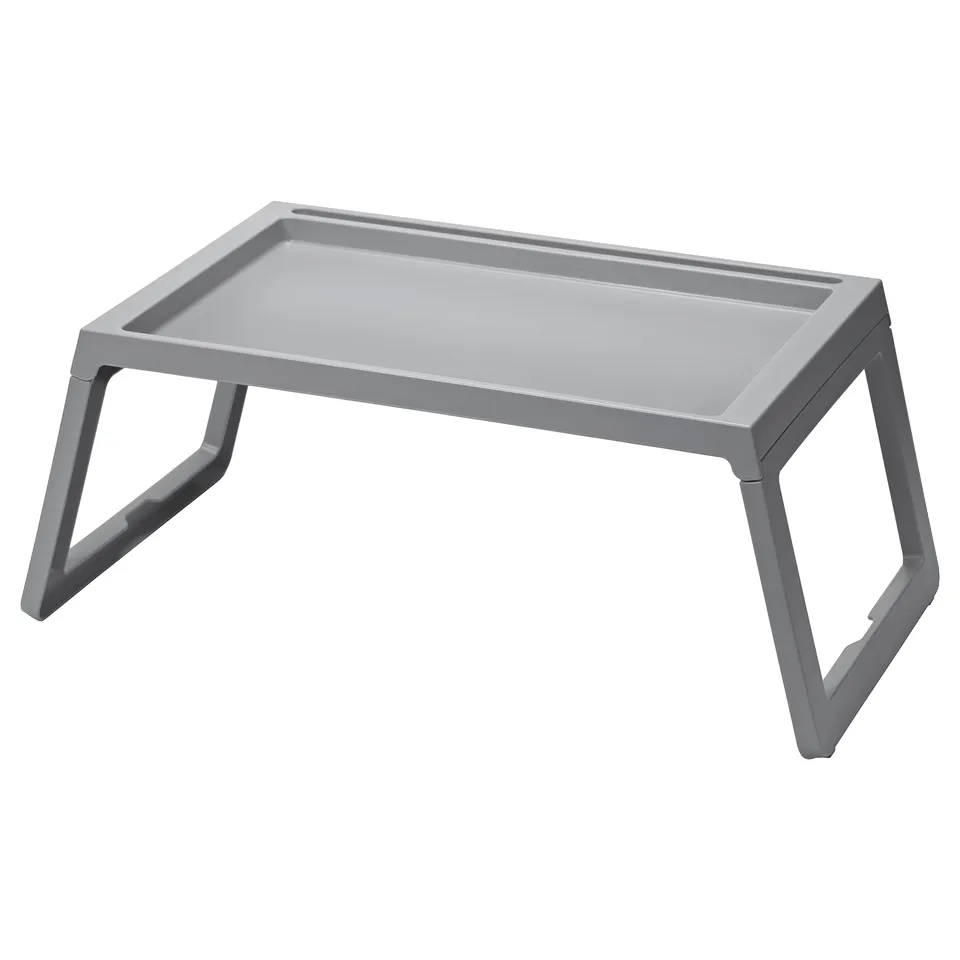 A grey, rectangular KLIPSK bed tray. Made of polypropylene plastic, it foldable legs for easy storage and a groove to hold a tablet or book.