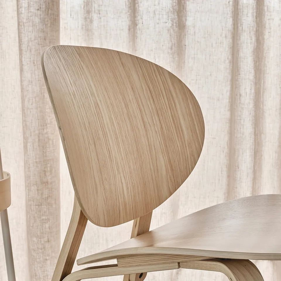 Light wooden chair, sleek modern design. Natural finish, curved back.