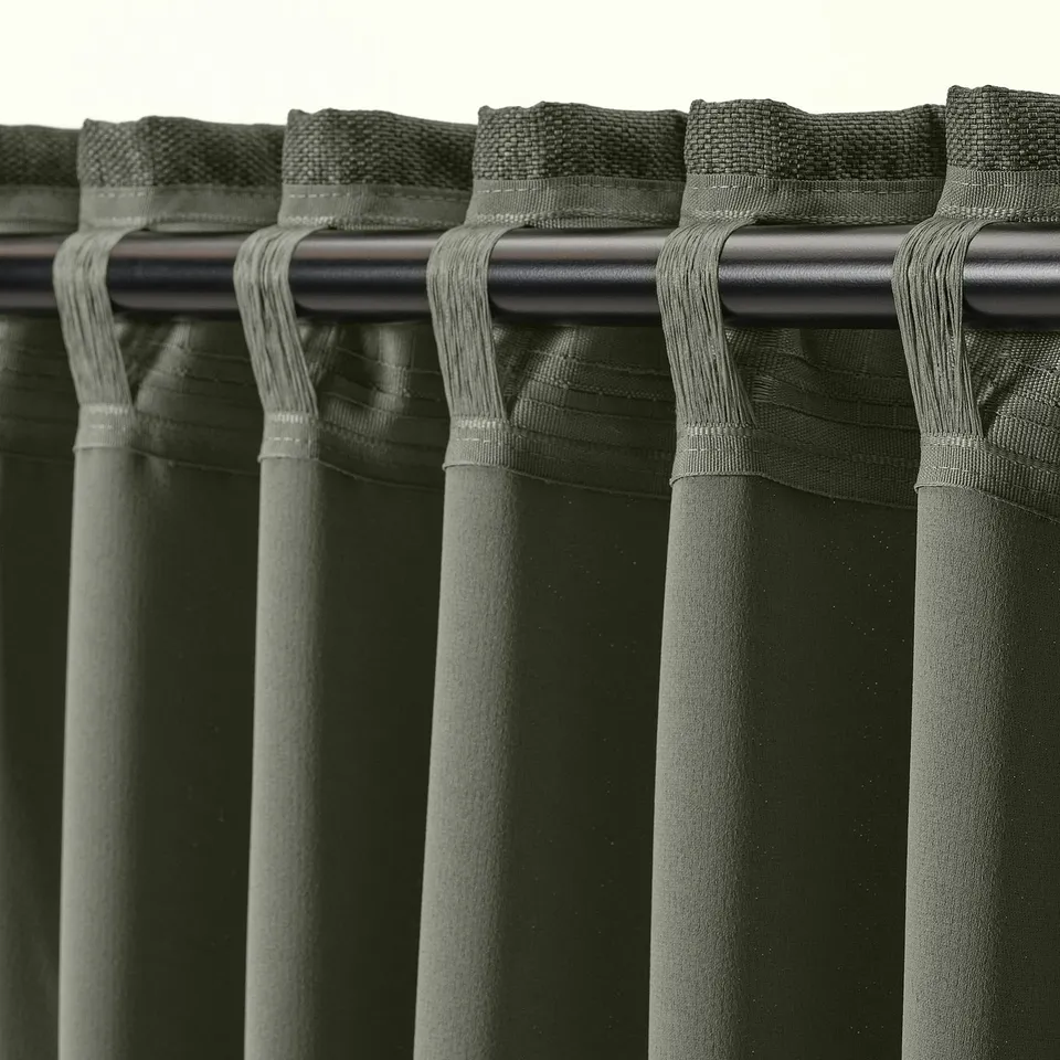 Close-up of curtains with heading tape and hooks, used for hanging on rods or gliders.