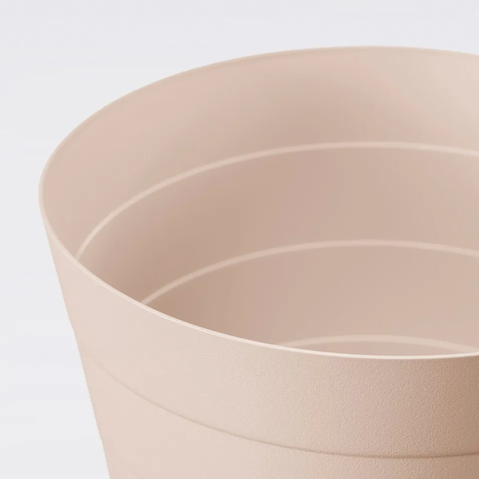 Smooth, peach-hued recycling bin made of durable, wipe-clean polypropylene.
