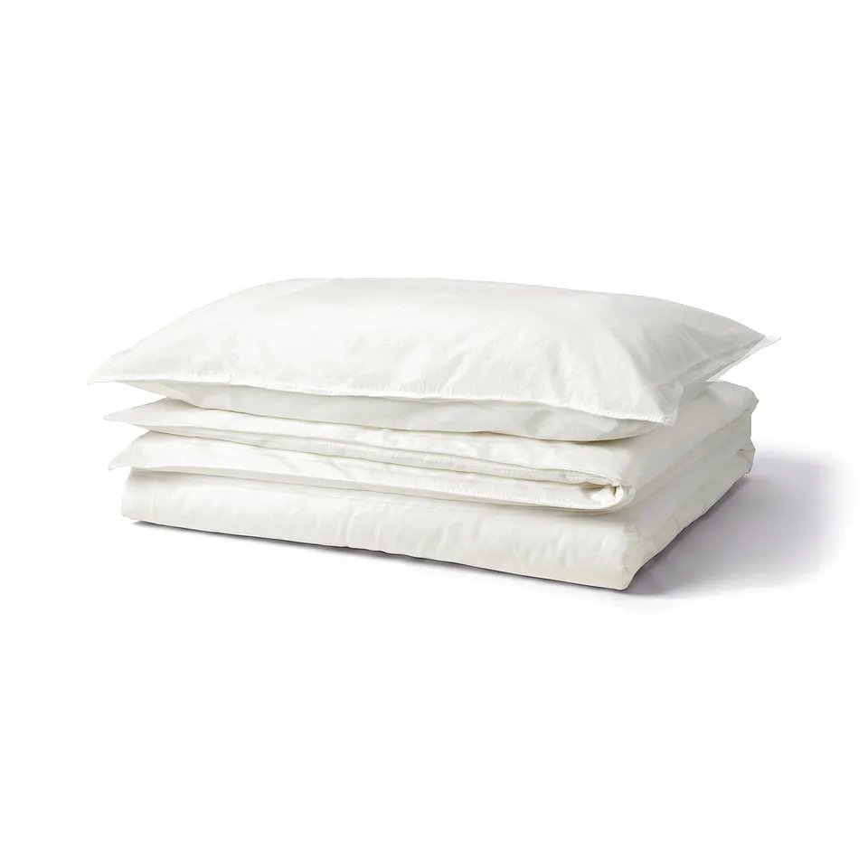 Stacked white ÄNGSLILJA cotton bedding, folded, with press studs.