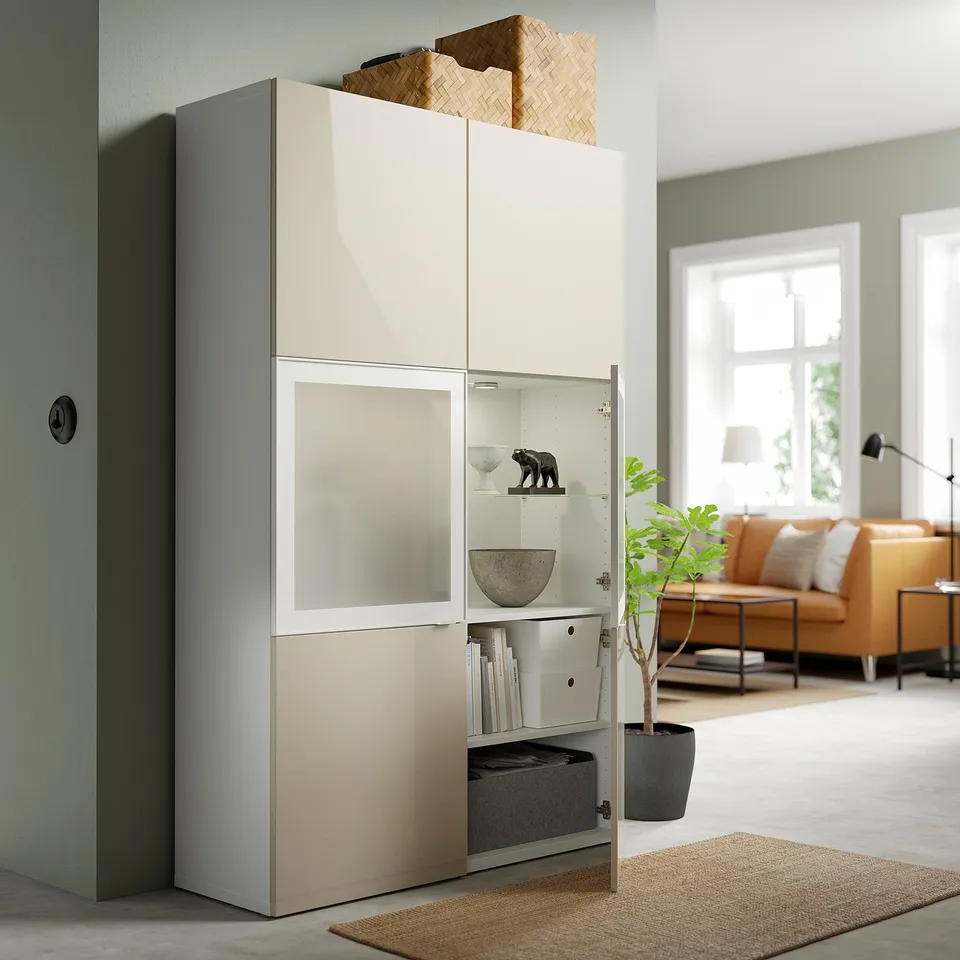 Modern storage cabinet with high-gloss beige doors; displays decorative items and stores books, showcasing a sleek, organised living room.
