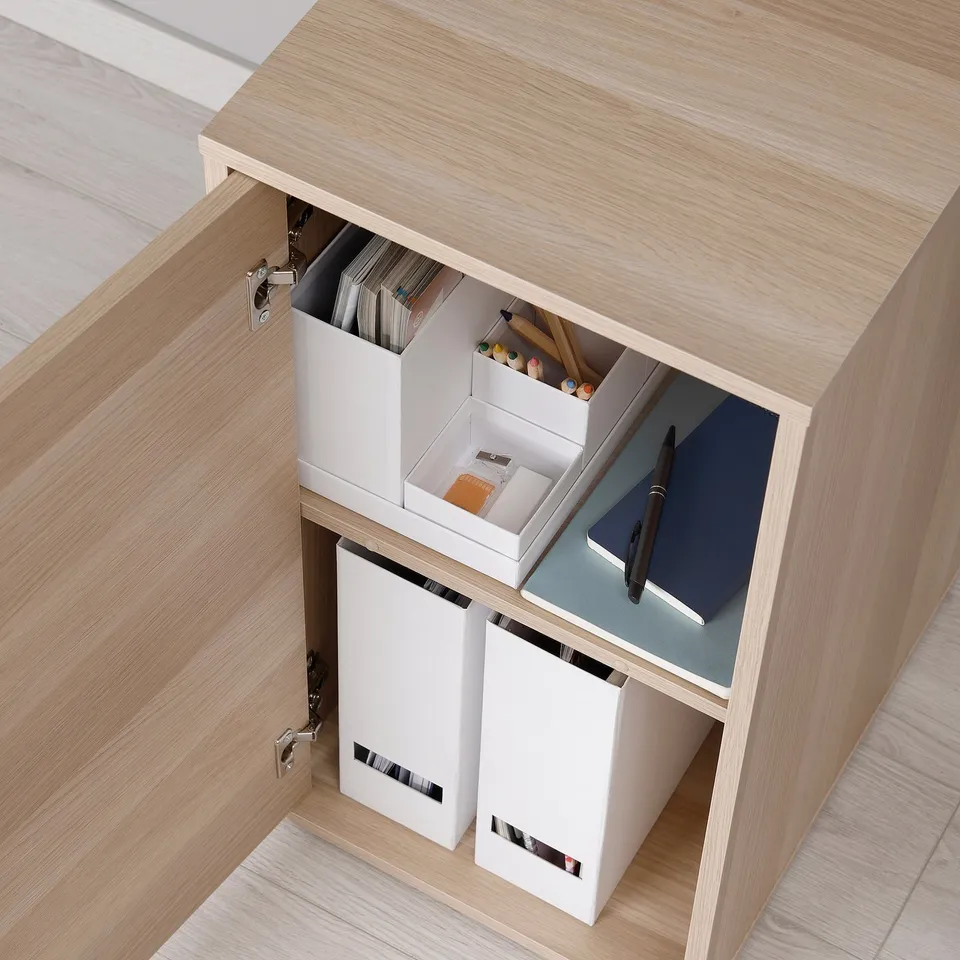 Wooden desk with open drawer showing organisers: files, pens, notebooks.