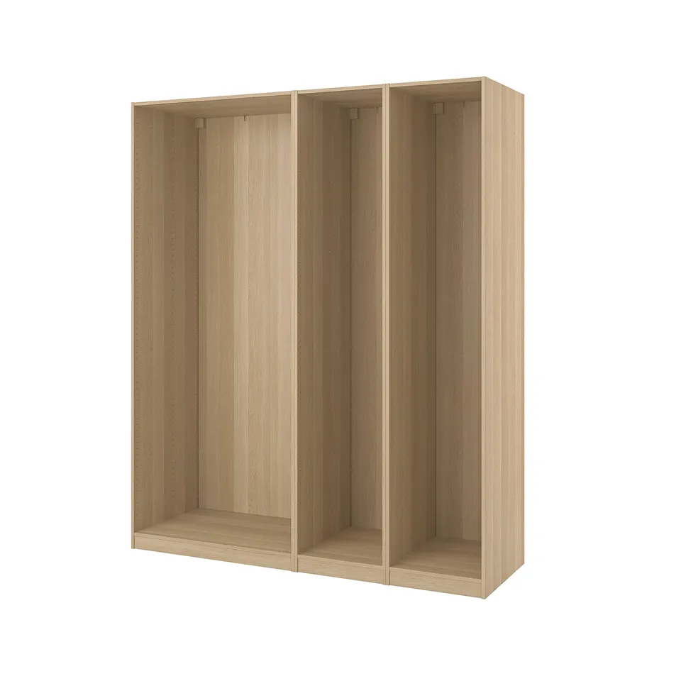 An ikea PAX wardrobe frame in light oak. Its rectangular with three empty sections for storage.
