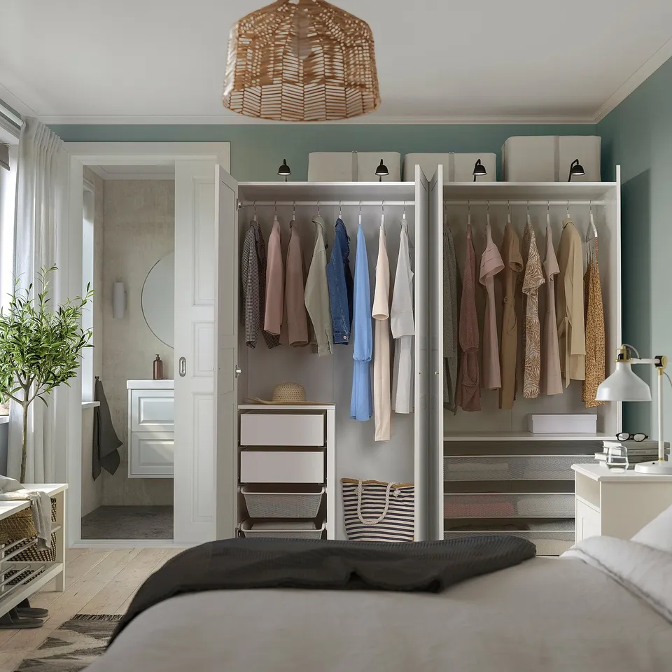Bedroom with open PAX wardrobe displaying clothes, storage, and organised interior.