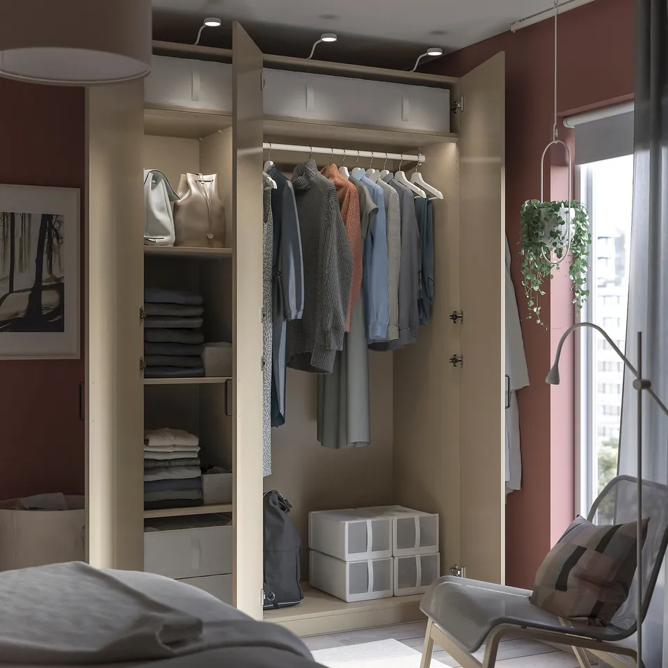 Modern walk-in closet with clothing, hanging bags, and storage boxes.