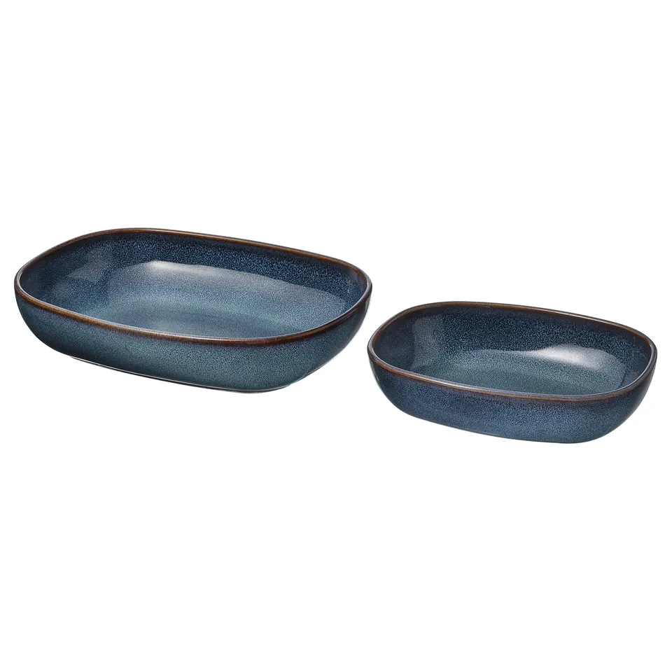 Blue stoneware oval dishes, large and small with gold rim, ready for serving meals.