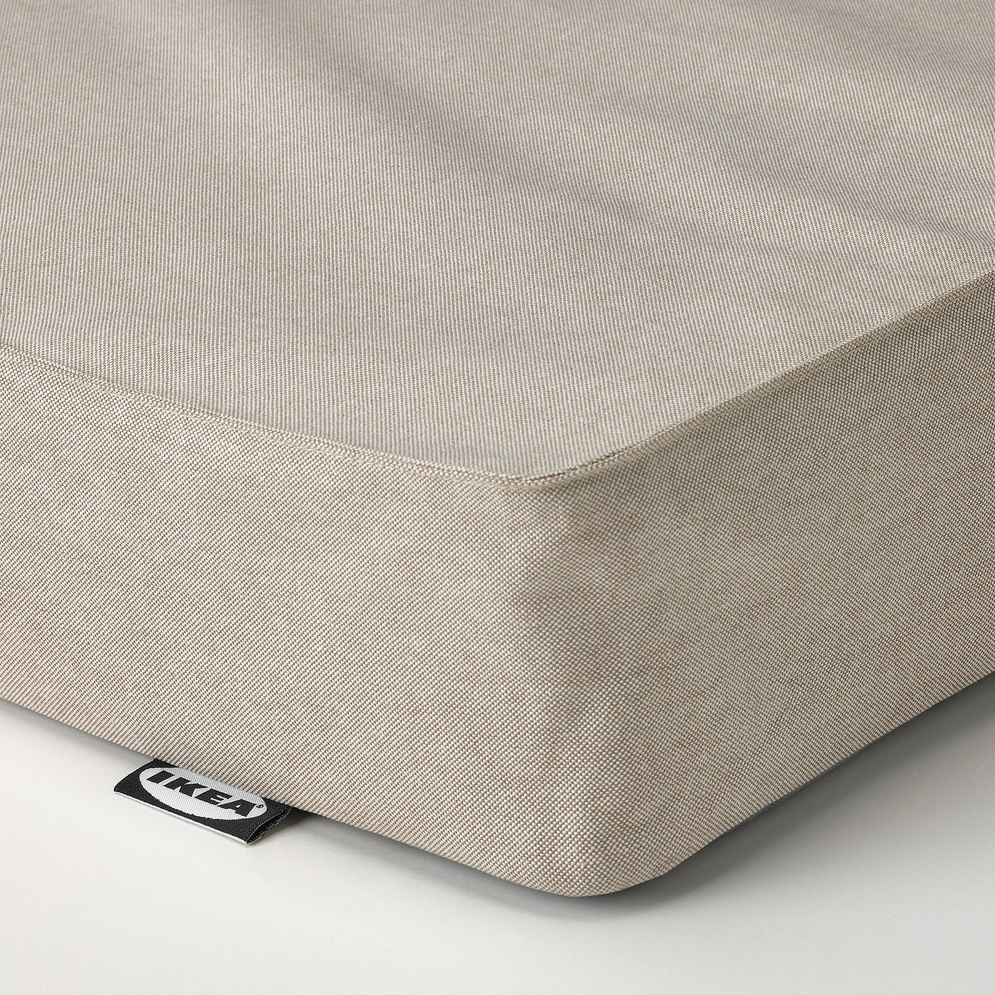 A close-up of a pristine, beige, textured mattress with a subtle grid pattern, showcasing its high-quality, even stitching and soft fabric.
