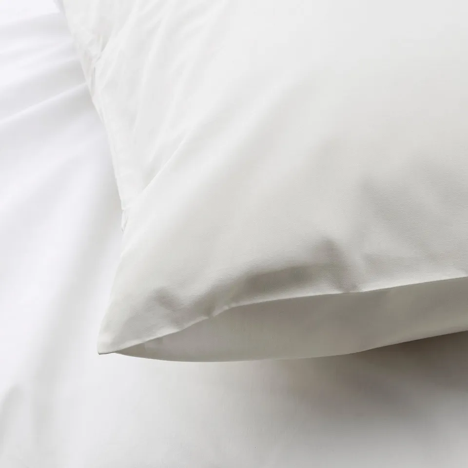 Close-up of crisp, white pillowcase with fine stitching, showcasing smooth texture and high-quality fabric.