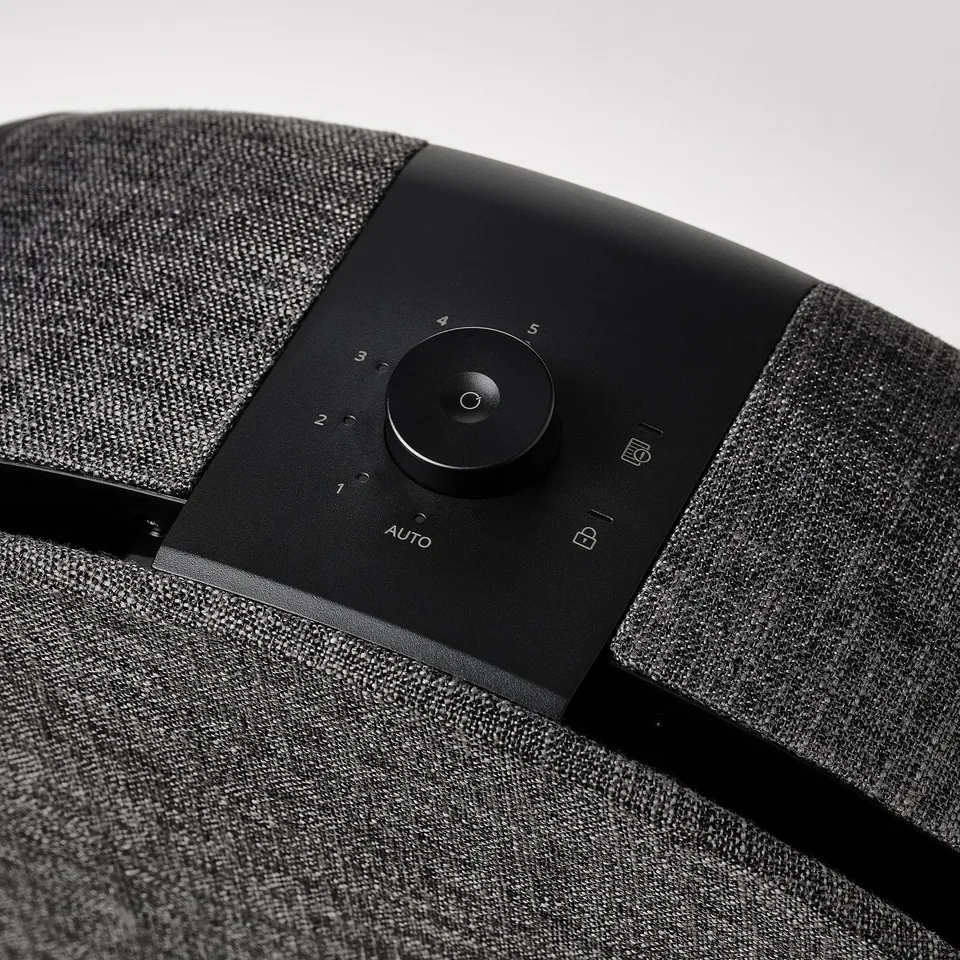Modern black air purifier with control dial, numbered 1-5, and auto setting. Integrated handle for easy movement.