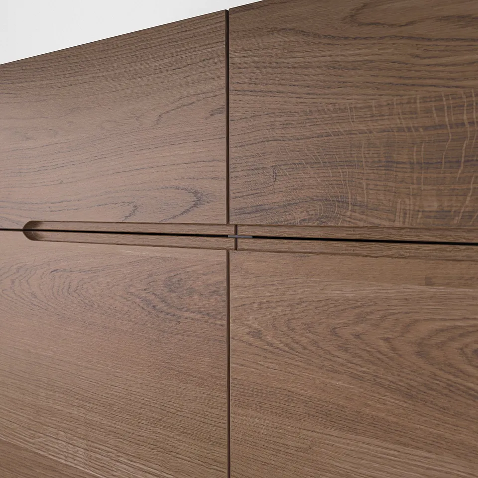 Close-up of KLACKENÄS sideboards oak veneer, showing smooth, integrated handles and high-quality wood grain detail.