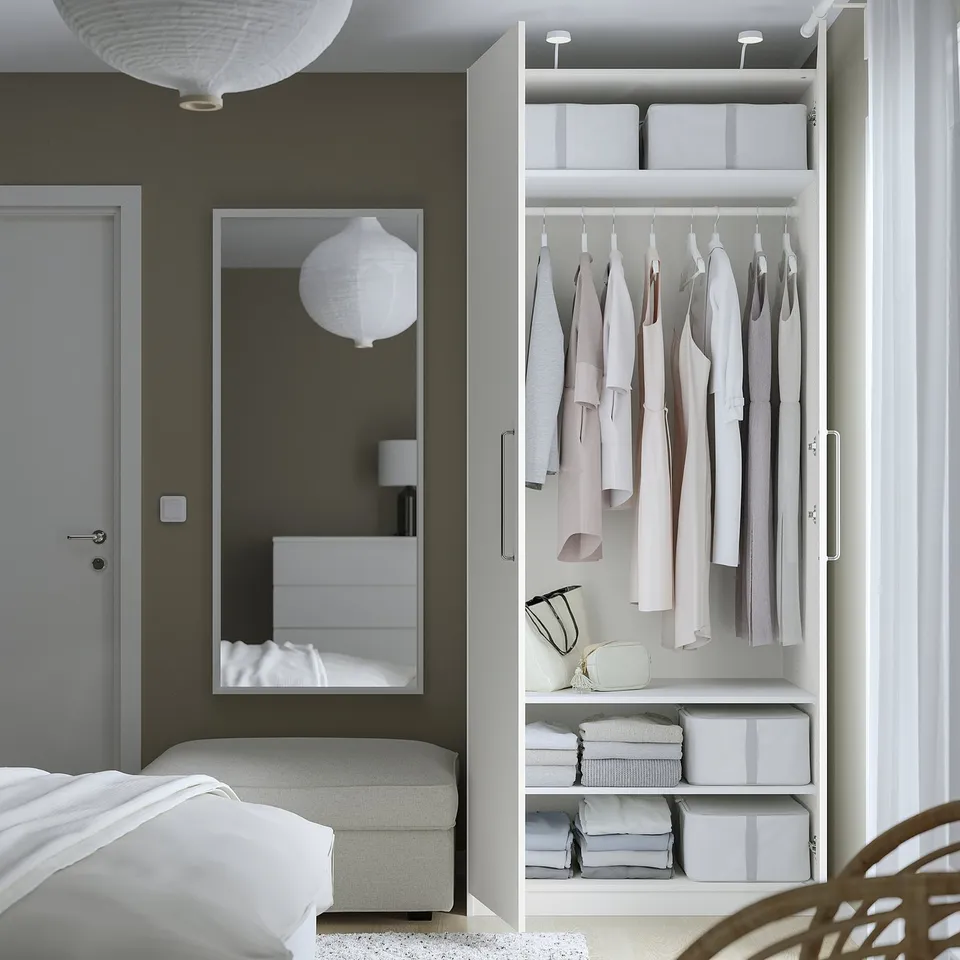 Modern bedroom with open wardrobe, showing clothes and organised storage, light grey and white.