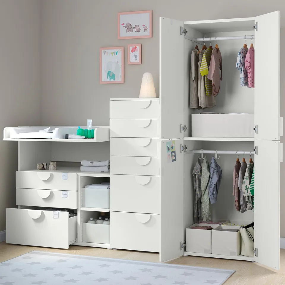 A white nursery storage unit with drawers, shelves, and hanging space for kids clothes and items.