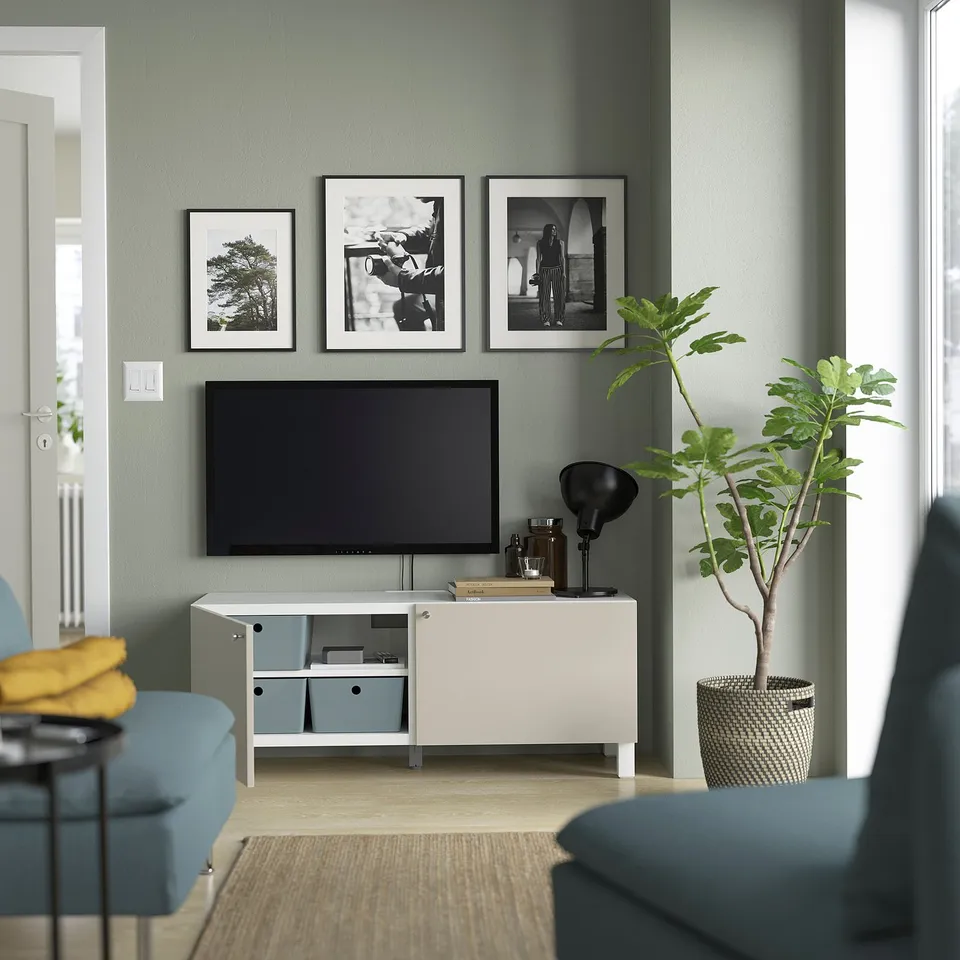 Modern living room with tv on stand, framed photos, and blue seating.