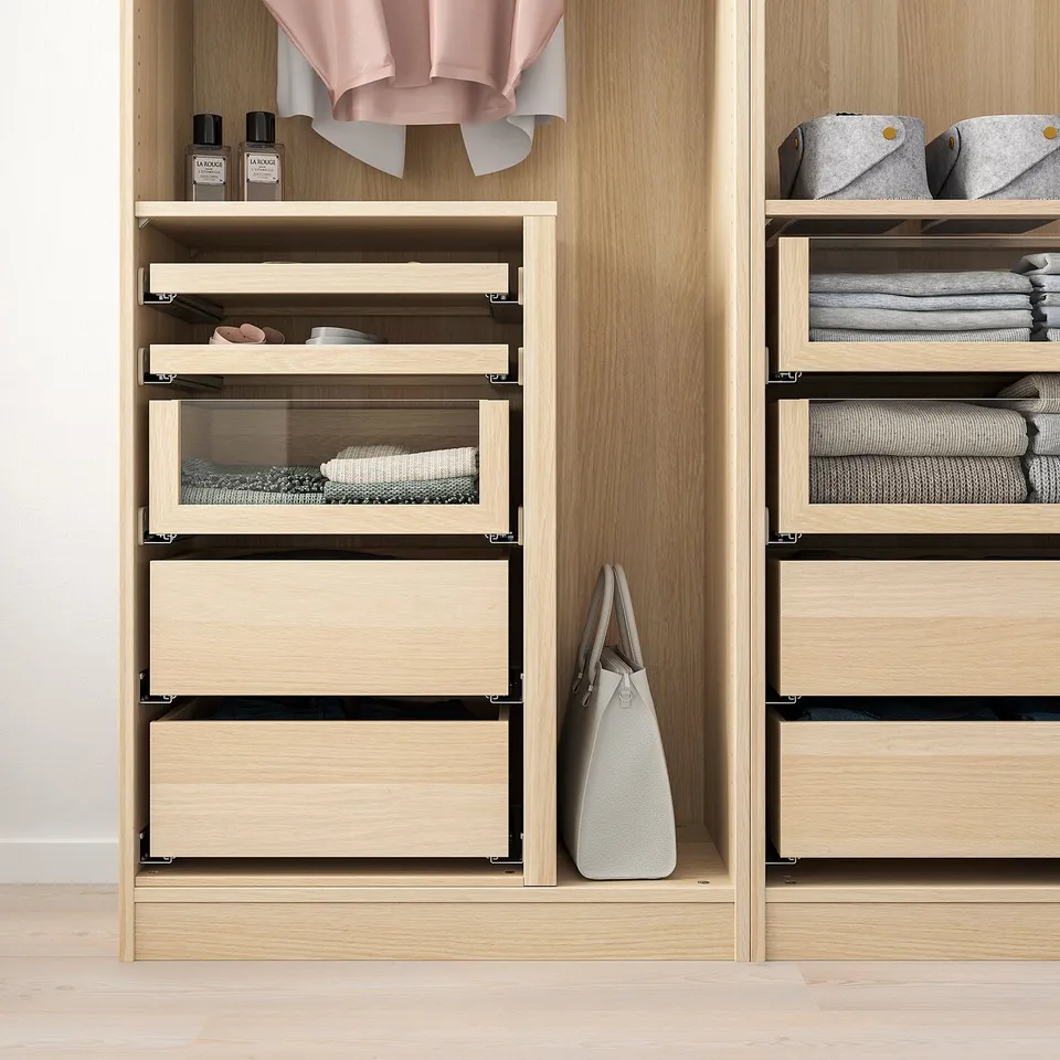 Modern wooden closet with glass-fronted drawers displaying neatly folded clothes, showcasing its organisational functionality.