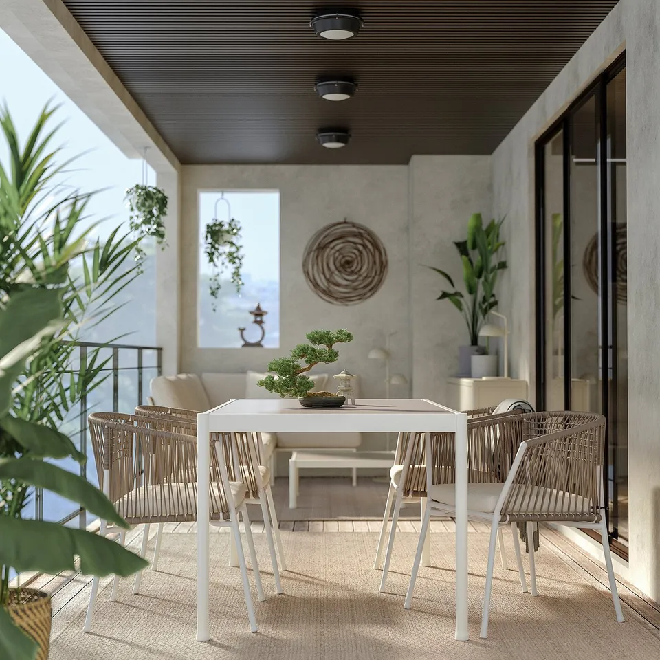 Modern balcony dining set with wicker chairs, plants, bonsai, and wall decor.