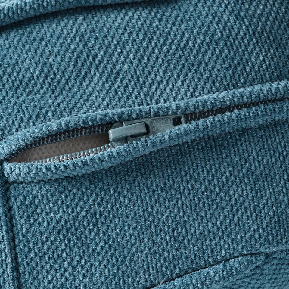 Close-up of a cosy, textured blue sofa with a zipped pocket, showcasing quality craftsmanship.