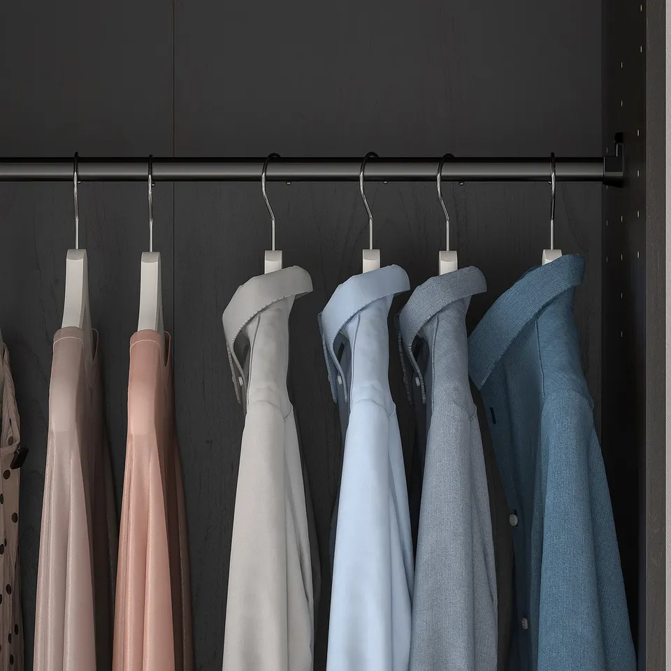 Closet with RAKKESTAD clothes hangers, holding shirts on hangers, dark background.