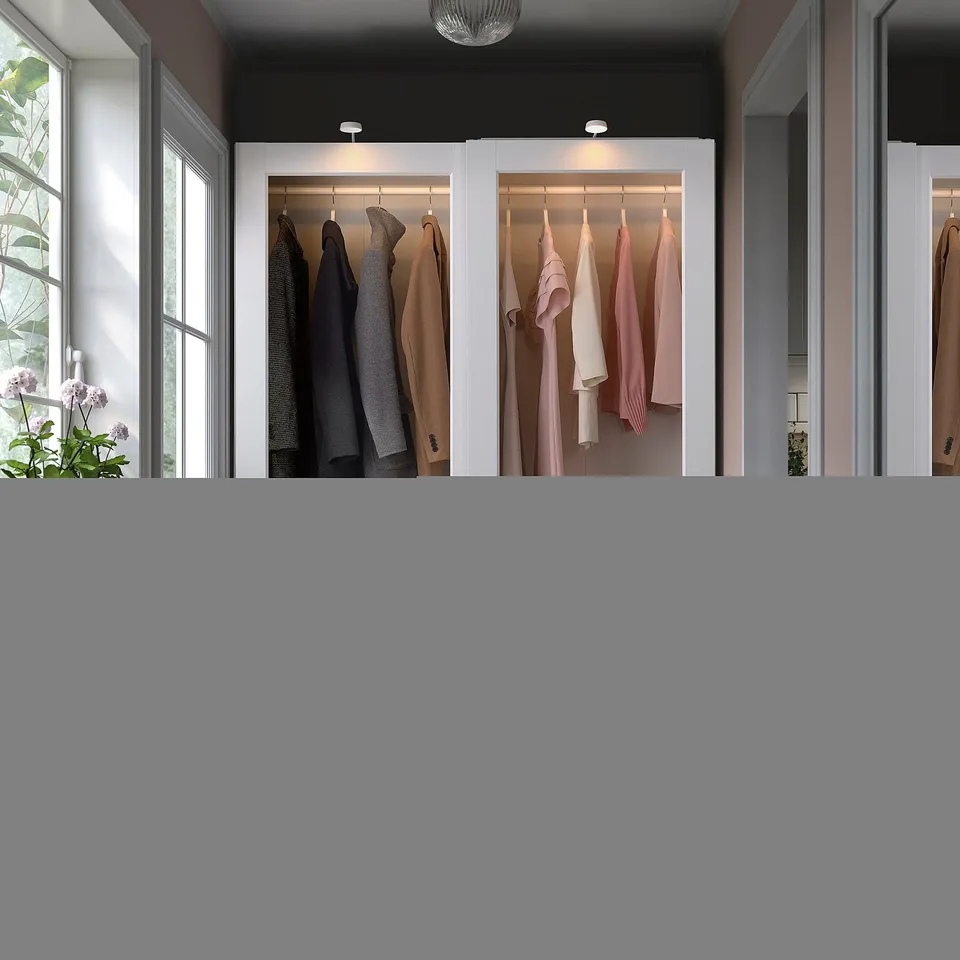 Modern wardrobe with sliding glass doors, integrated lighting, grey & pink clothes, lush greenery.