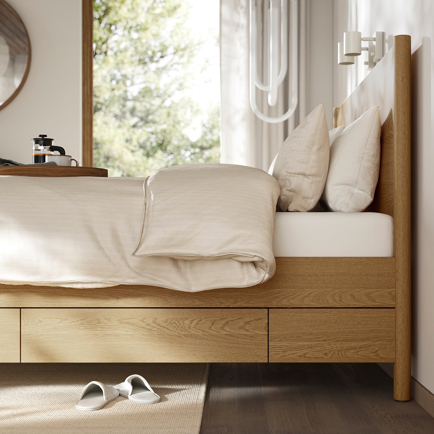 Modern wooden bed with drawers, light bedding, slippers by rug, coffee by window.