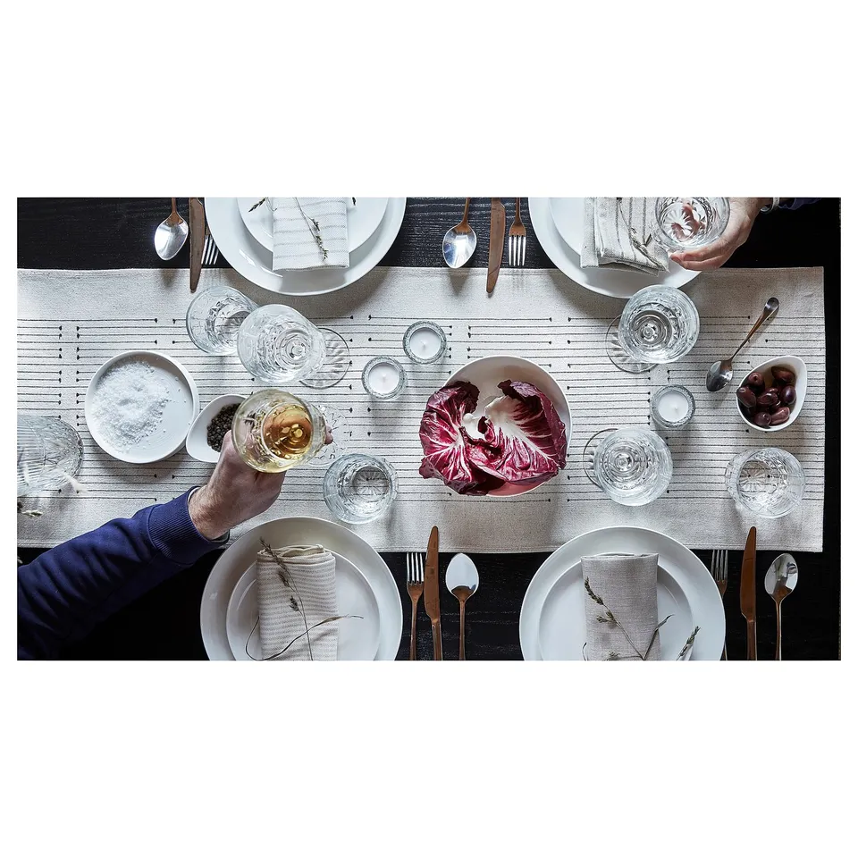 Table set with VÅRARV runner, plates, glasses, cutlery, red cabbage. Earthy tones, subtle patterns, rustic elegance.
