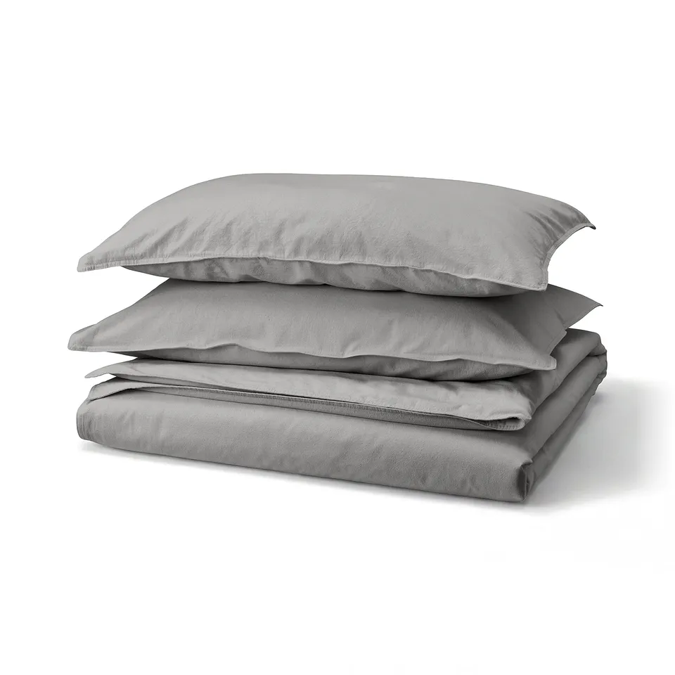 Grey bedding set: two pillows, folded flat sheet, all in soft washed cotton.