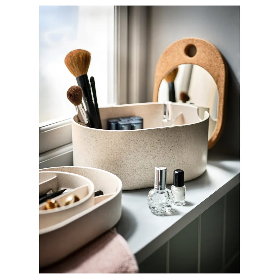 White SAXBORGA box with makeup tools, nail polish, and mirror. On counter with dish.