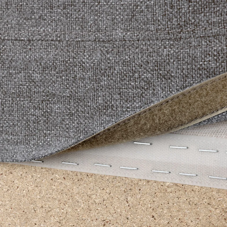 Close-up of grey fabric and foam layers, showing detachable, washable sofa cover with loops.