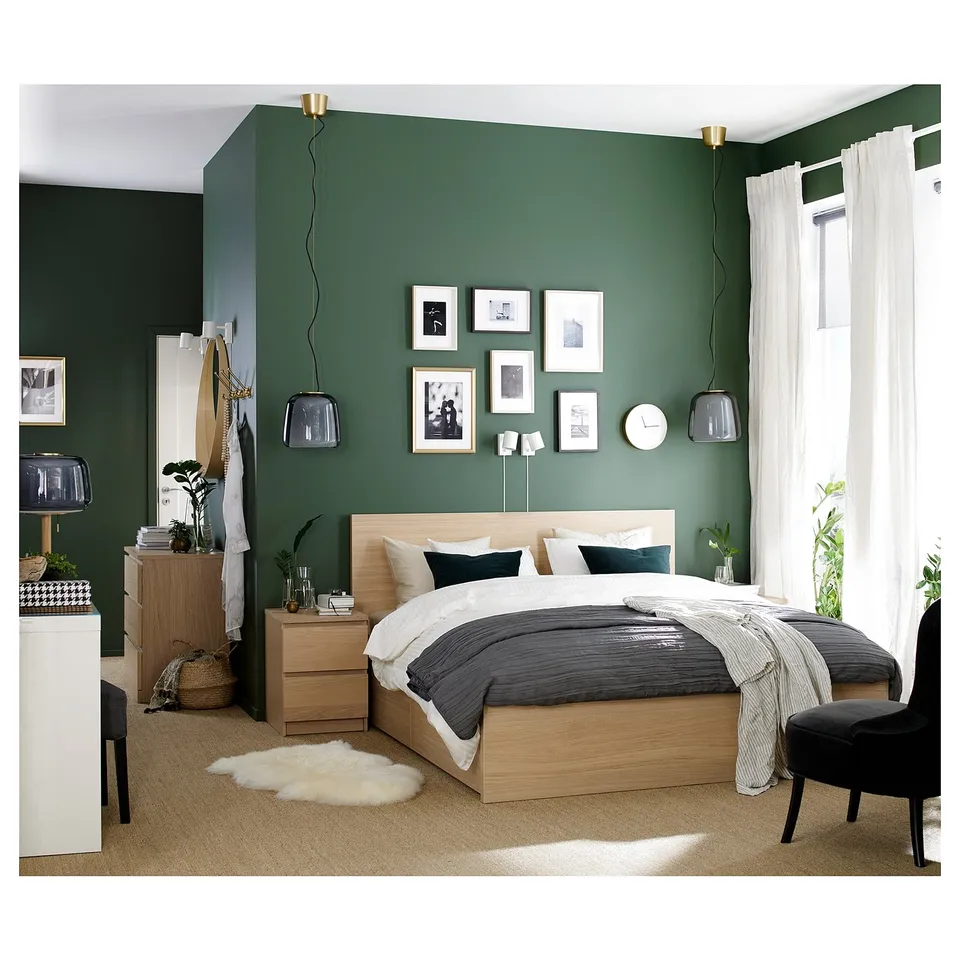 Modern bedroom with MALM light oak bed, green walls, white curtains, pendant lights, and cosy textiles.