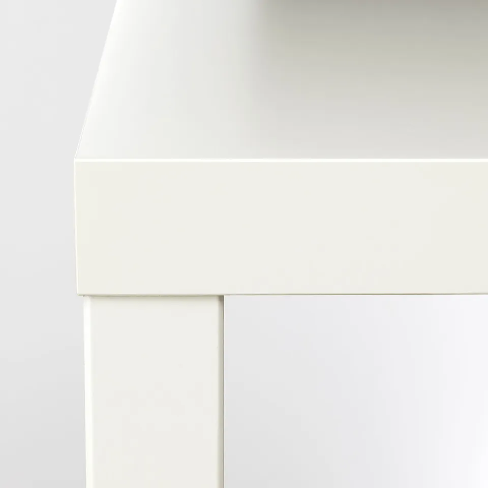Close-up of modern white LACK table corner, smooth surfaces & clean lines, showcasing quality materials & design.