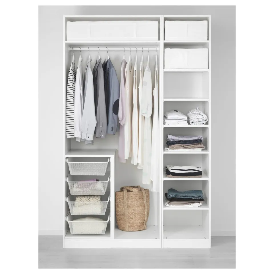 A white PAX wardrobe hanging clothes, folded garments on shelves, and mesh baskets for storage.