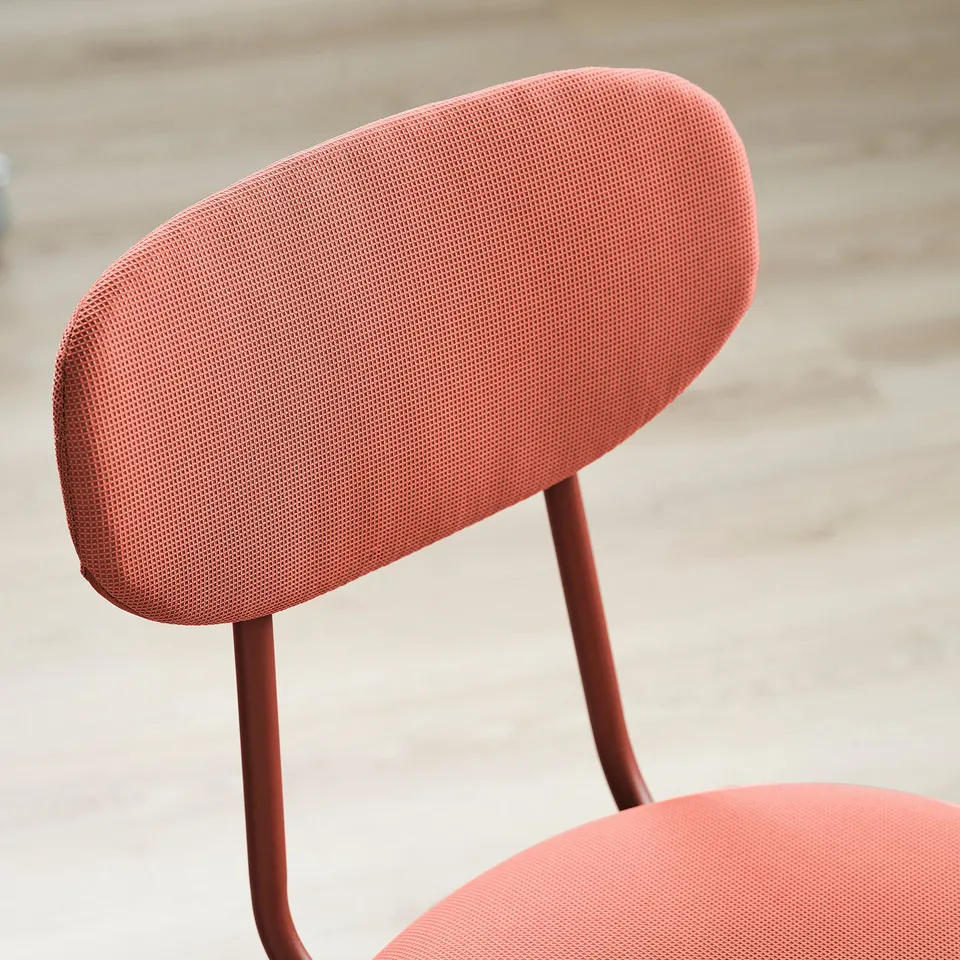 Red upholstered chair with metal legs, showcasing soft fabric and sturdy base.