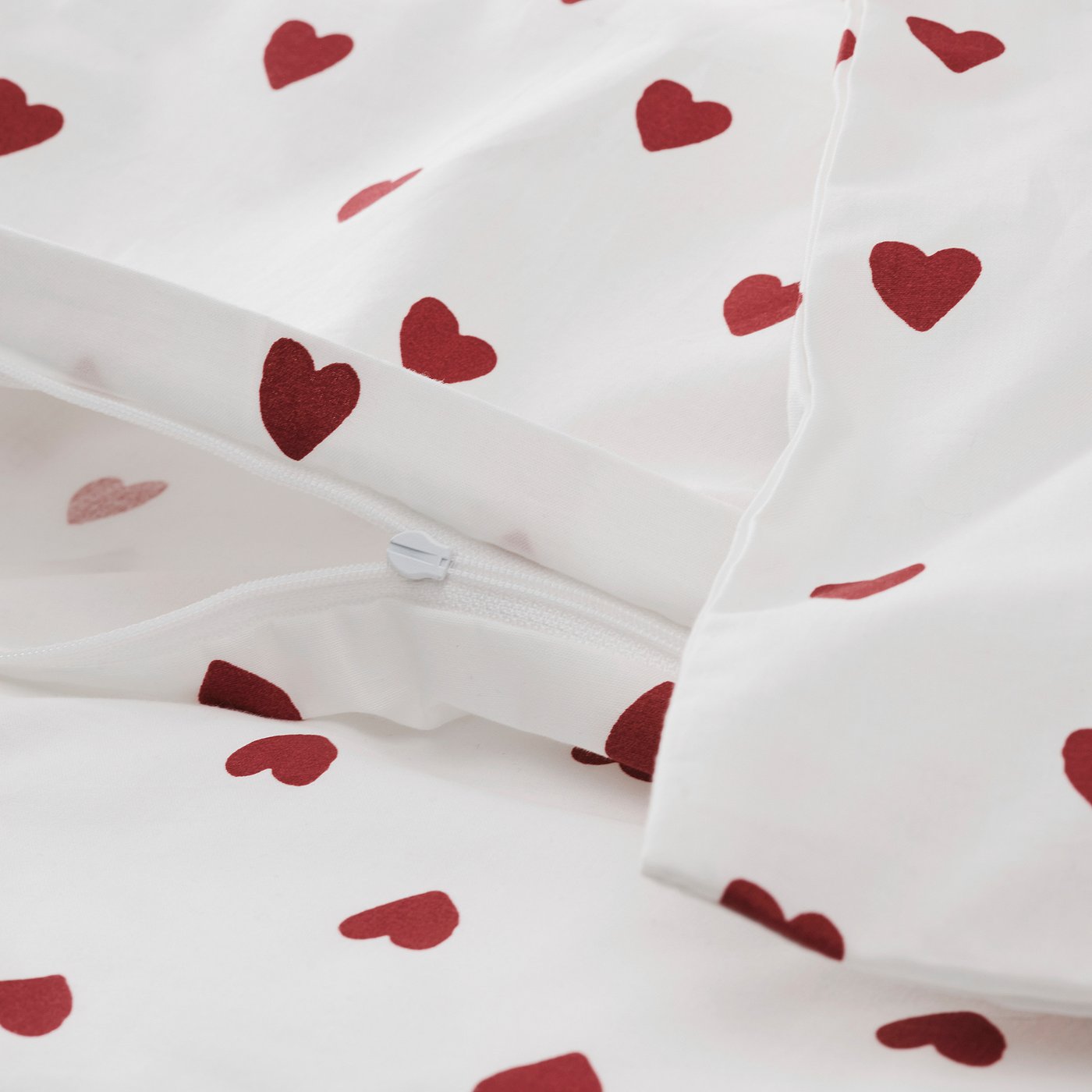 White baby duvet cover with red heart patterns and a zip.