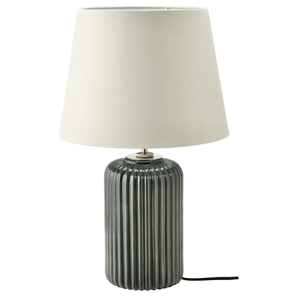A modern table lamp named SNÖBYAR with a ribbed grey ceramic base and a beige fabric lampshade.