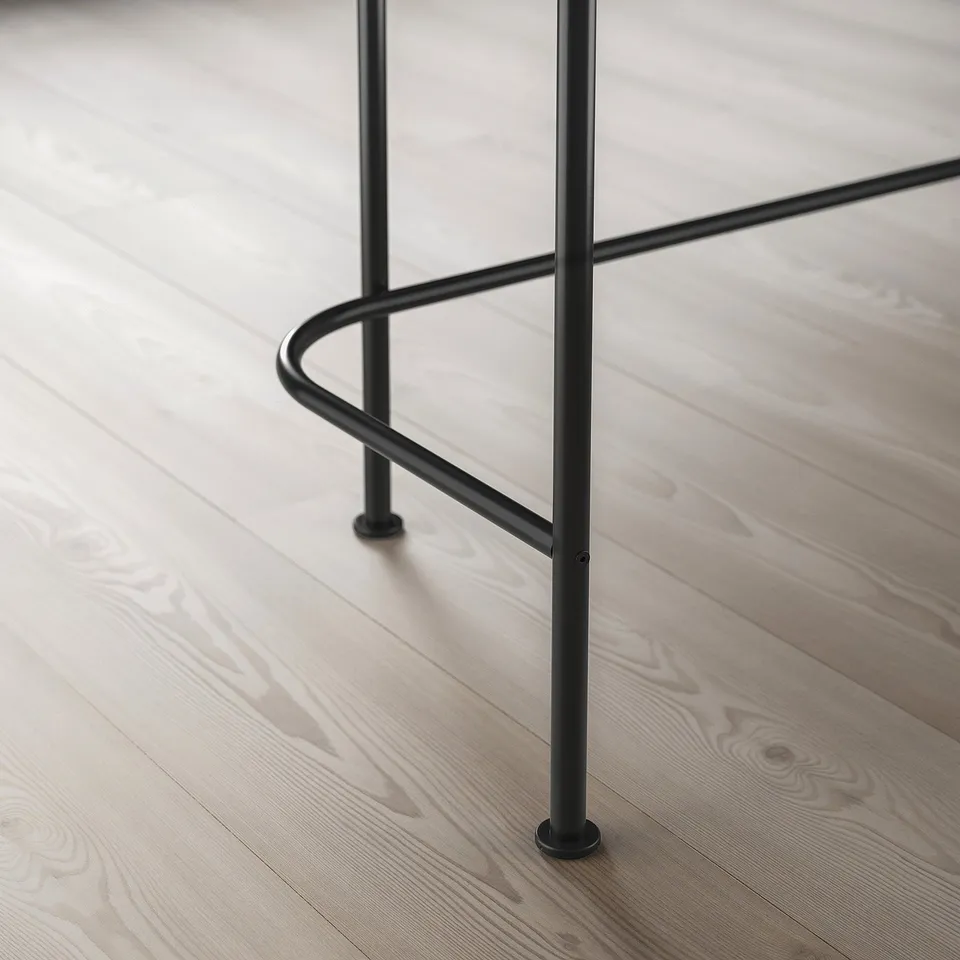 Modern dressing table with sleek black metal legs and wooden floor, polished and sturdy, reflecting minimalist design.