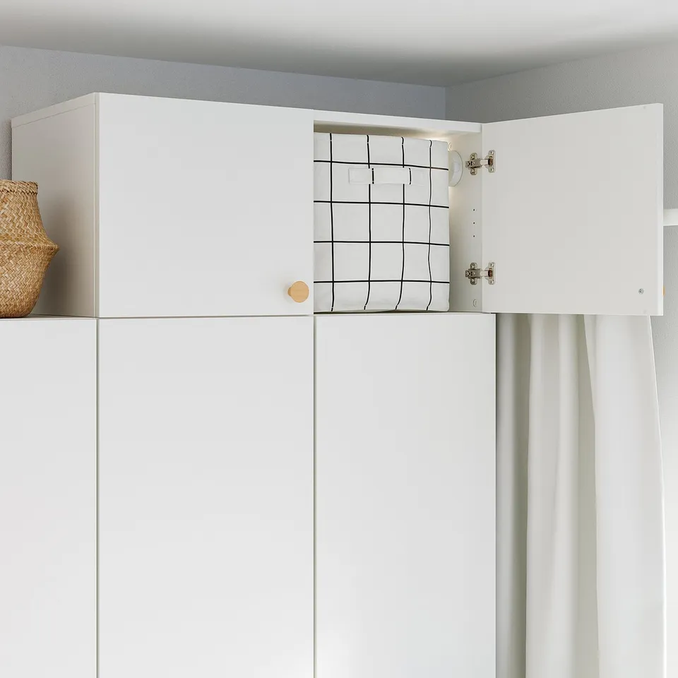 White cabinet with one open door revealing grid storage, ideal for vertical space.