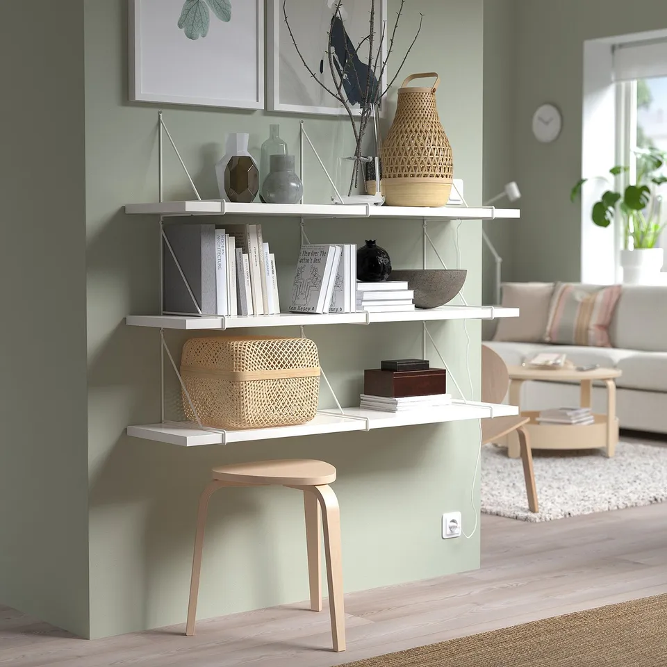 Minimalist BERGSHULT shelf with books, vases, decor. Wood stool, green walls, natural light.