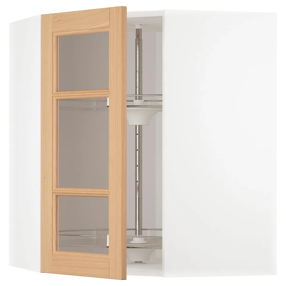 An open wooden cabinet with glass doors from IKEAs METOD kitchen system in oak. It an adjustable shelf and a carousel for easy access.