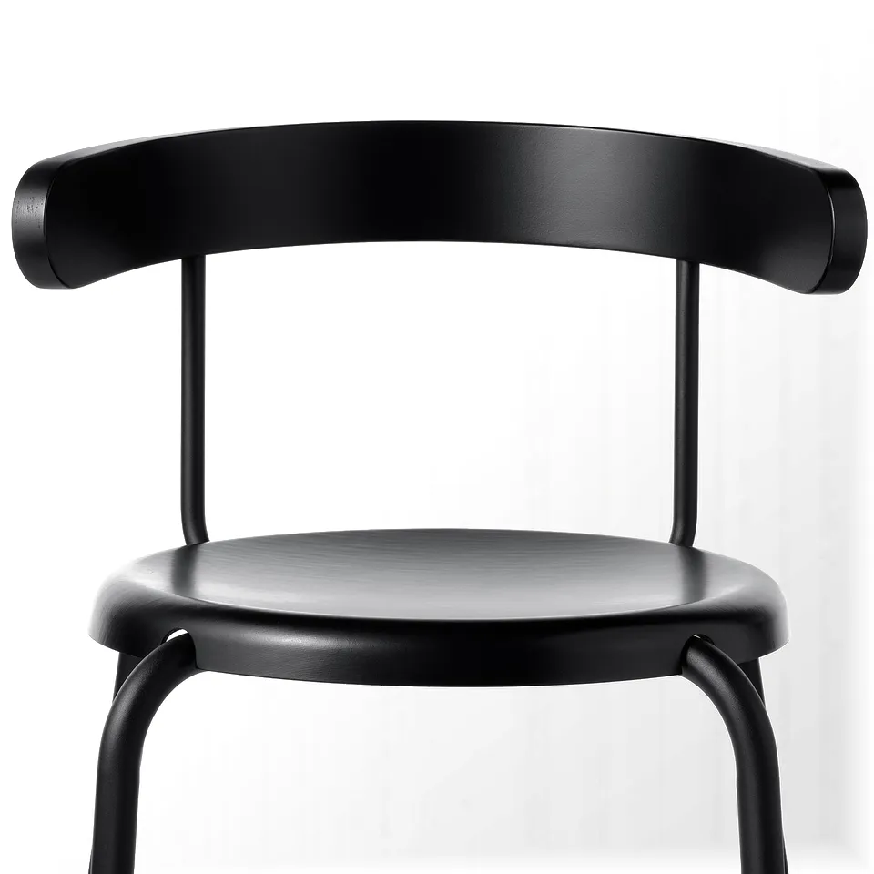 Black chair with rounded back, smooth seat, sturdy metal legs.